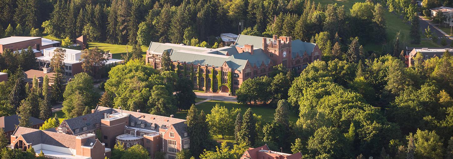 An aerial view of the U of I Moscow campus, showcasing green trees and the Administration Building.