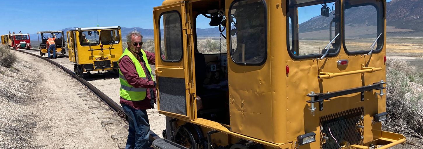 Thomas Griggs stands next to his restored railroad maintenance car.